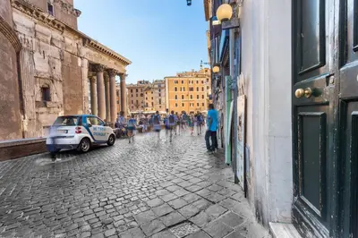 a group of people walking down a cobblestone street at Hub Pantheon in Rome