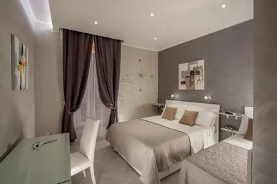 a bedroom with a bed and a desk and a chair at Frattina Grand Suite Guesthouse in Rome