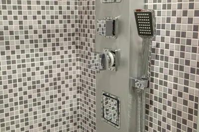 a shower with gray and white tiles in a bathroom at Frattina Grand Suite Guesthouse in Rome