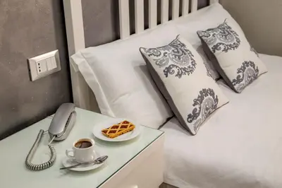 a bed with a phone and a plate of waffles on a table at Frattina Grand Suite Guesthouse in Rome