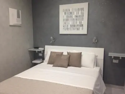 a bedroom with a bed with white sheets and pillows at Frattina Grand Suite Guesthouse in Rome