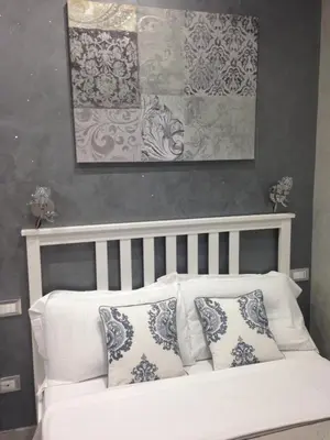 a white couch with pillows in a room with a painting at Frattina Grand Suite Guesthouse in Rome