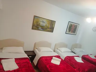 a room with three beds with red sheets and a painting on the wall at Host Roma in Rome