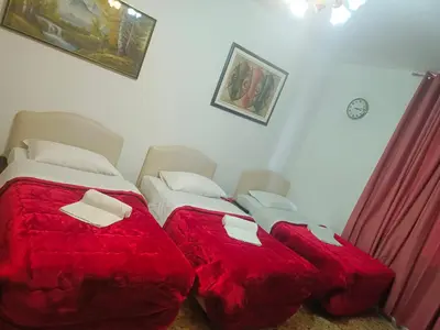two beds in a bedroom with red comforter at Host Roma in Rome