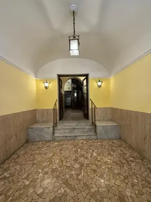 an empty room with stairs and a ceiling with a chandelier at Host Roma in Rome