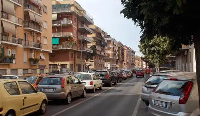 a line of cars parked on a city street at Roma Tourist House in Rome