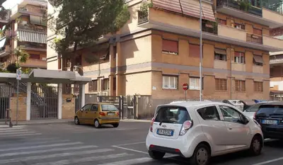 a small car is driving down a city street at Roma Tourist House in Rome