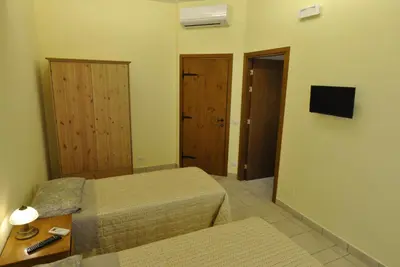 a small bedroom with two beds and a mirror at Roma Tourist House in Rome