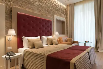 a bedroom with a large bed and a brick wall at Navona Luxury Guesthouse in Rome