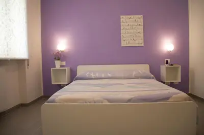 a bedroom with a bed with a purple wall at DaNoi in Trastevere in Rome