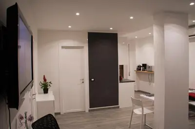 a living room with a black door and a kitchen at DaNoi in Trastevere in Rome