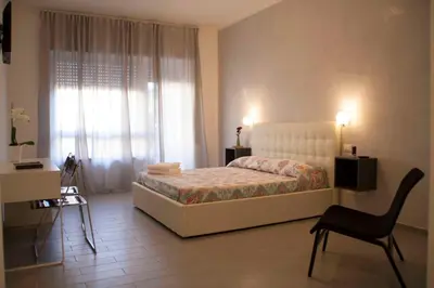 a bedroom with a bed and a chair and a window at DaNoi in Trastevere in Rome