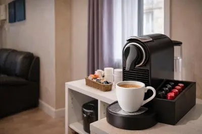 a coffee maker and a cup of coffee on a table at Tollì rooms in Rome