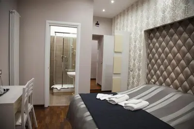 a bedroom with a bed and a sink and a bathroom at Maison Imperiale in Rome