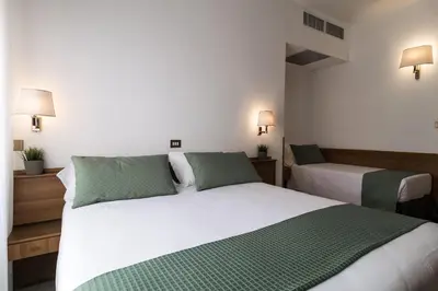 a bedroom with two beds with green and white sheets at Hotel Pacific in Rome