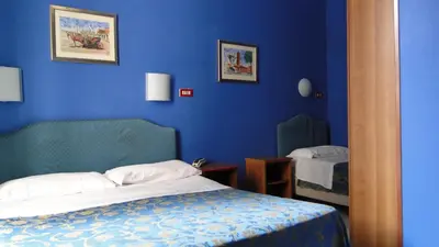 a bedroom with blue walls and a bed and a mirror at Hotel Altavilla Dieci in Rome