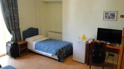 a bedroom with a bed and a desk with a television at Hotel Altavilla Dieci in Rome