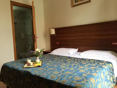 a hotel room with a bed with a tray of flowers on it at Hotel Altavilla Dieci in Rome