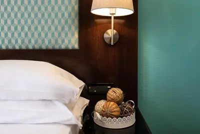 a bed with two pillows in a bedroom with two lamps at Merulana Inn Guest House in Rome