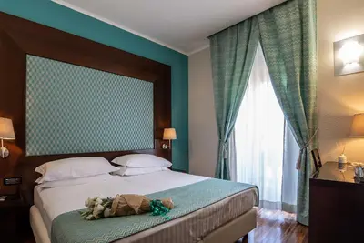 a bedroom with a bed with a teddy bear on it at Merulana Inn Guest House in Rome
