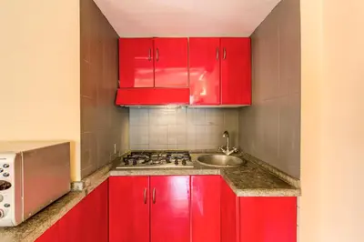 a kitchen with red cabinets and a sink at Trastevere Attic with Terrace in Rome