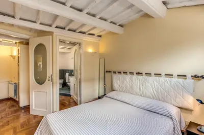 a bedroom with a white bed and a hallway at Trastevere Attic with Terrace in Rome