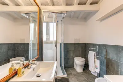 a bathroom with a sink and a shower and a toilet at Trastevere Attic with Terrace in Rome