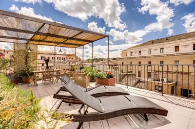 a patio with a table and chairs on a balcony at Trastevere Attic with Terrace in Rome