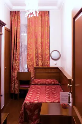 a bedroom with a red bed and a window at Hotel Caravaggio in Rome