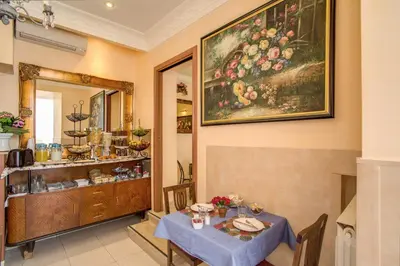 a dining room with a table and a painting on the wall at Hotel Caravaggio in Rome