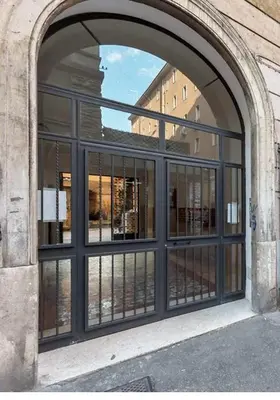 an arched window in a building with black windows at Rome La Sapienza Apartment in Rome