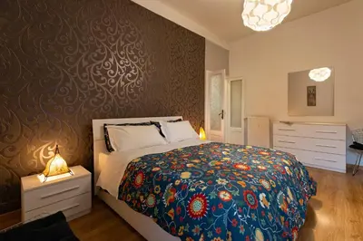 a bedroom with a large bed with a floral bedspread at Rome La Sapienza Apartment in Rome