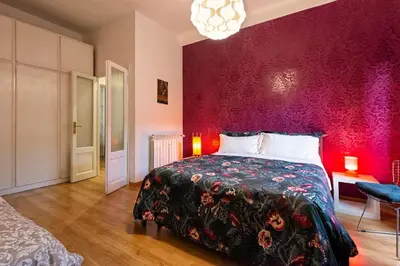 a bedroom with a bed and a red wall at Rome La Sapienza Apartment in Rome