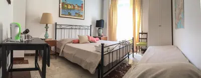a bedroom with two beds and a table and a desk at Bausan 12 in Rome