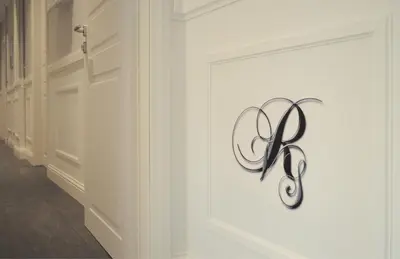 a white wall with a metal sign on it at Residenza Vatican Suite in Rome