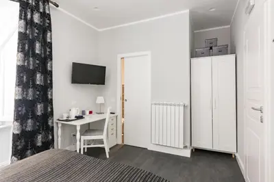 a bedroom with a bed and a desk and a tv at Residenza Vatican Suite in Rome