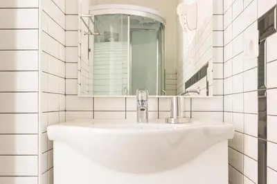 a white bathroom with a sink and a mirror at Residenza Vatican Suite in Rome