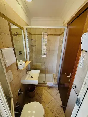 a bathroom with a shower and a toilet and a sink at Hotel Principe Di Piemonte in Rome