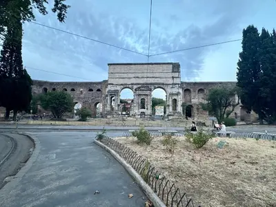 a large stone building with an arch in the background at Hotel Principe Di Piemonte in Rome