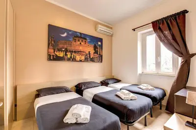 a room with four beds in it with a painting on the wall at Aurelia Vatican Apartments in Rome