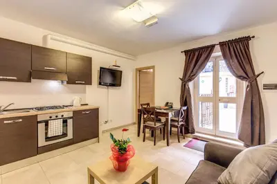 a kitchen and living room with a couch and a table at Aurelia Vatican Apartments in Rome