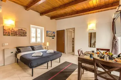 a bedroom with a bed and a table in a room at Aurelia Vatican Apartments in Rome