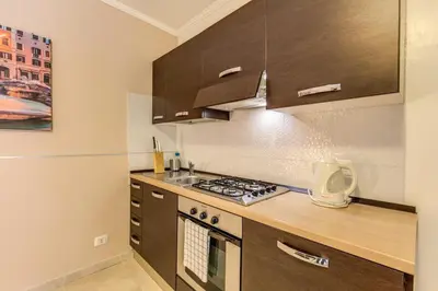 a kitchen with brown cabinets and a stove top oven at Aurelia Vatican Apartments in Rome