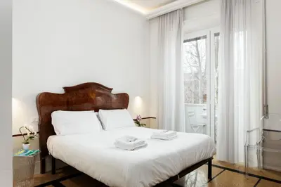a white bedroom with a large bed with white sheets at Gatsby Guest House - Zen 60 in Rome