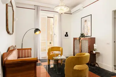 a living room with yellow chairs and a table at Gatsby Guest House - Zen 60 in Rome