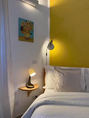 a bedroom with a bed and a table with a lamp at Green Rooms Trastevere in Rome