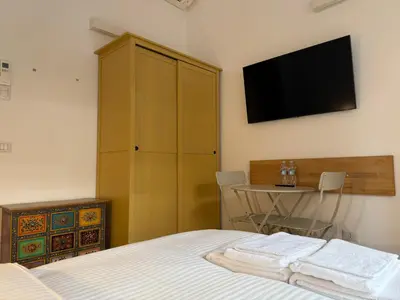 a bedroom with a bed and a tv on the wall at Green Rooms Trastevere in Rome