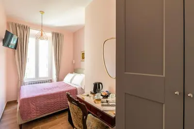 a bedroom with a bed and a desk with a table at Queen Meg Roma in Rome