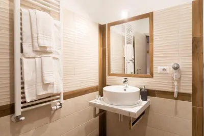 a bathroom with a sink and a mirror and towels at Queen Meg Roma in Rome