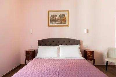 a bedroom with a large bed with a purple blanket at Queen Meg Roma in Rome
